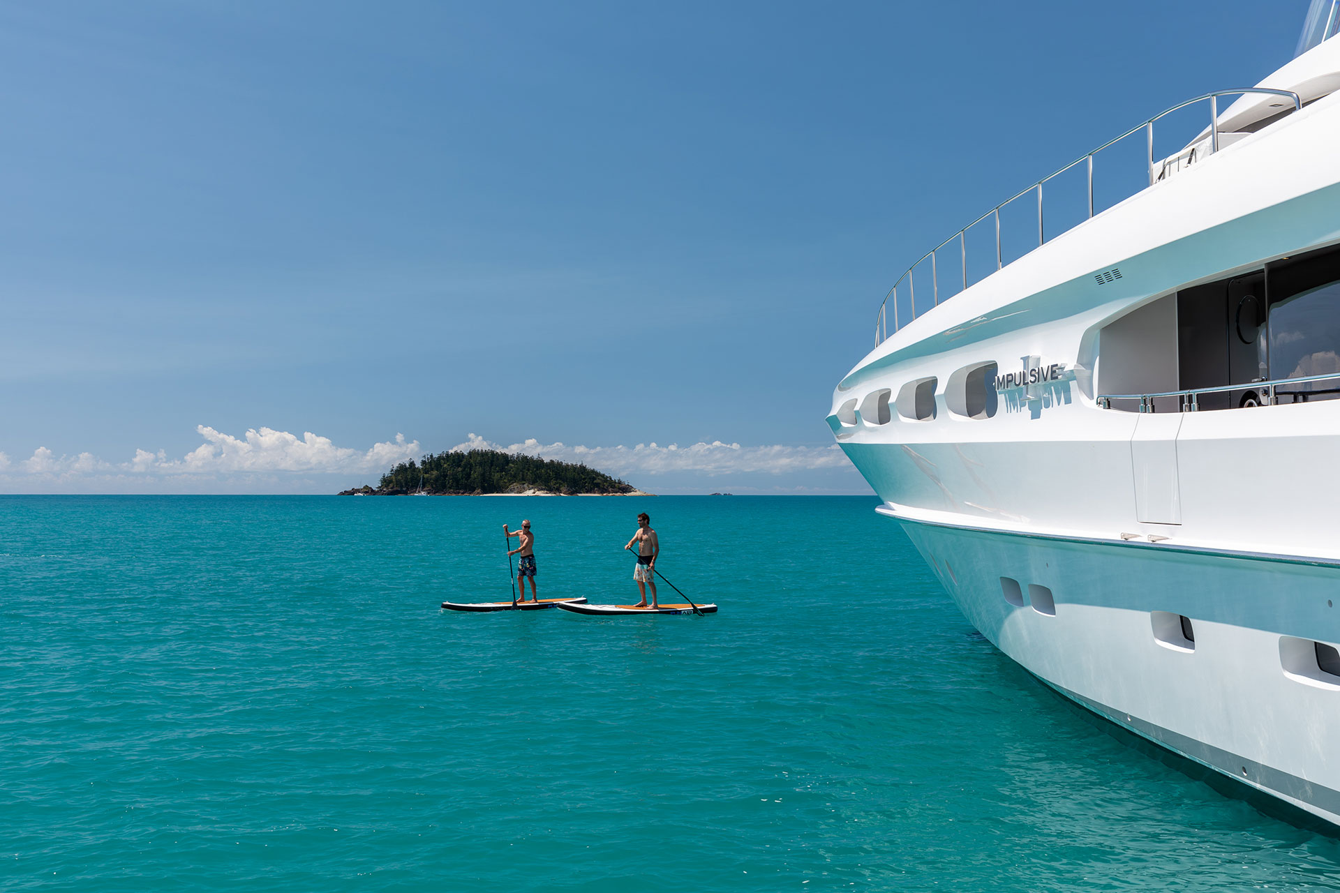 Impulsive Yacht Guests Paddleboarding On Whitsundays Charter